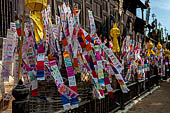 Chiang Mai - The Wat Phan Tao temple, small chedi shaped structures decorated with colorfull flags on the southern side wall of the Wihan 